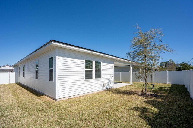 638 Honeycomb Trl, Saint Augustine, FL 32095 - view of side of home with a lawn, an attached carport, and a fenced backyard