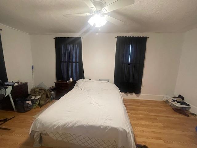 bedroom featuring a textured ceiling, hardwood / wood-style flooring, and ceiling fan