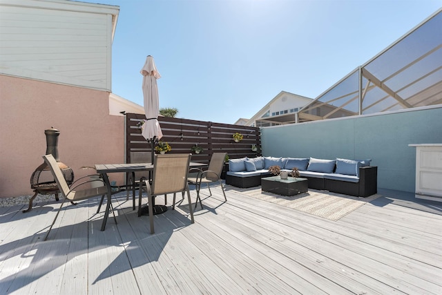 wooden terrace featuring outdoor lounge area, outdoor dining area, and fence