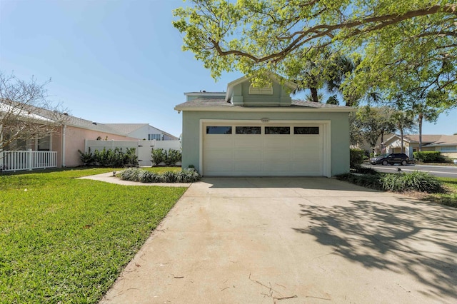 garage featuring concrete driveway and fence