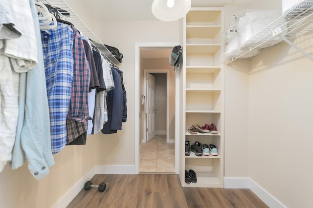 walk in closet with wood finished floors