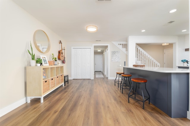 kitchen featuring baseboards, a breakfast bar, and wood finished floors