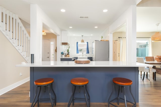 kitchen featuring visible vents, dark wood finished floors, pendant lighting, recessed lighting, and freestanding refrigerator