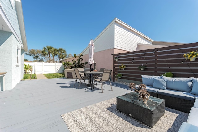 deck featuring outdoor dining space, outdoor lounge area, and a fenced backyard