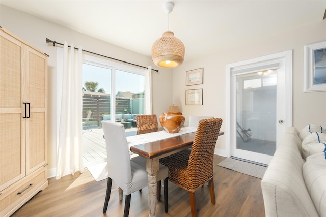 dining space with baseboards and light wood-style floors