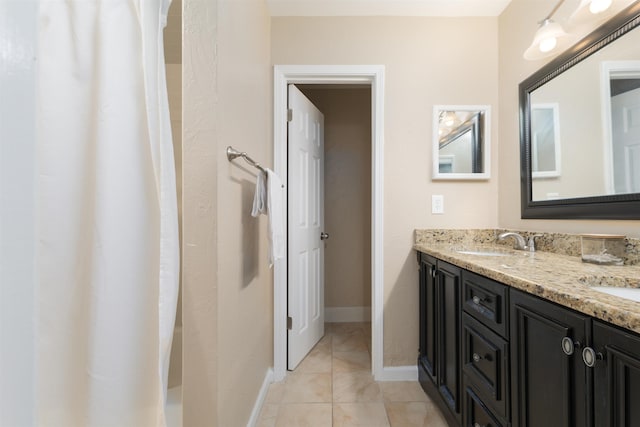 full bathroom with a sink, a shower with shower curtain, tile patterned flooring, double vanity, and baseboards