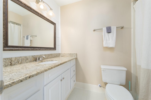 bathroom with tile patterned flooring, toilet, vanity, and baseboards