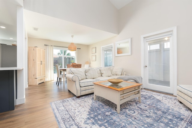 living room with visible vents, recessed lighting, and wood finished floors