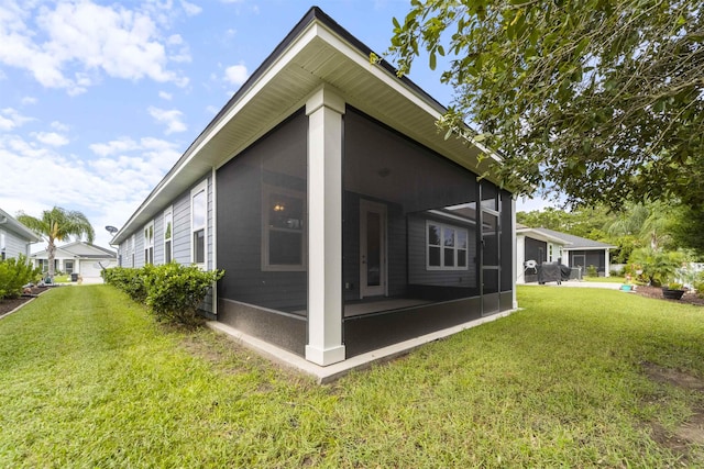 back of property with a lawn and a sunroom