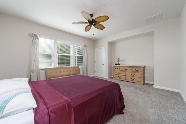 carpeted bedroom featuring a textured ceiling and ceiling fan