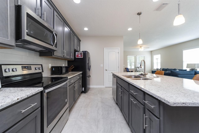 kitchen with sink, a kitchen island with sink, plenty of natural light, and black appliances