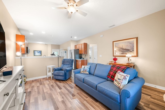 living room featuring light wood-type flooring and ceiling fan