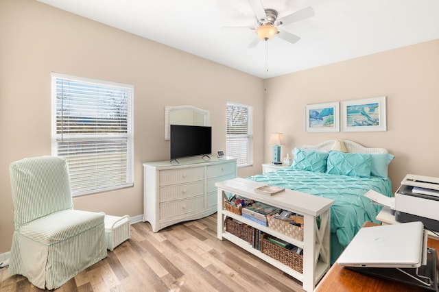 bedroom featuring light wood-type flooring, ceiling fan, and multiple windows