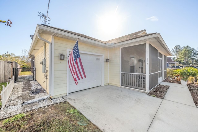 view of side of home featuring a garage and a sunroom