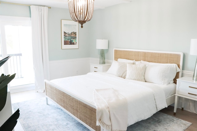 bedroom featuring wood finished floors and a notable chandelier