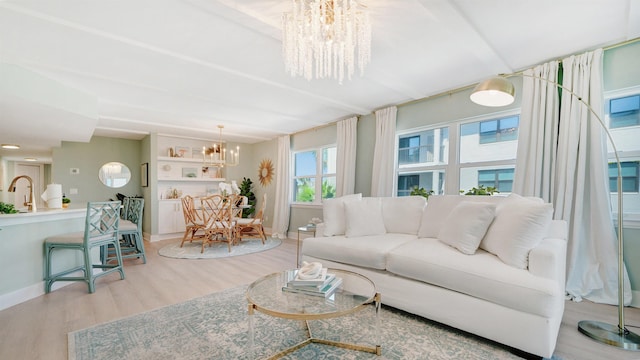 living room featuring baseboards, wood finished floors, and a notable chandelier