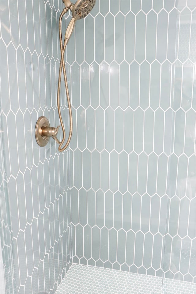 interior details featuring a tile shower