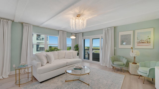 living room with a notable chandelier, baseboards, and wood finished floors