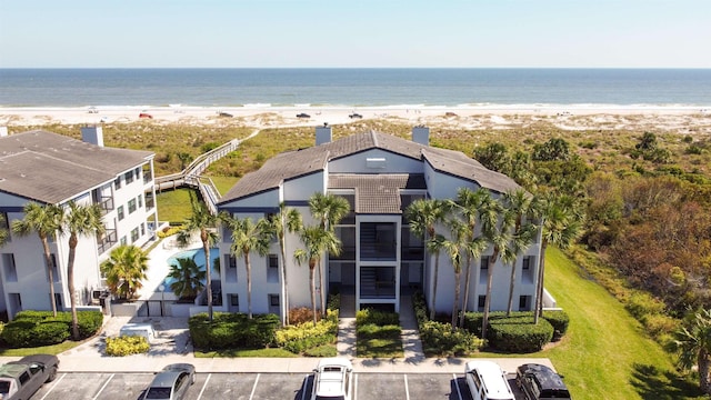 birds eye view of property featuring a water view and a beach view