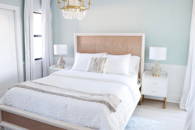 bedroom featuring wood finished floors and a notable chandelier