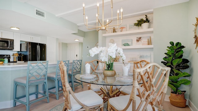 dining area featuring baseboards, visible vents, light wood-style flooring, a chandelier, and beam ceiling