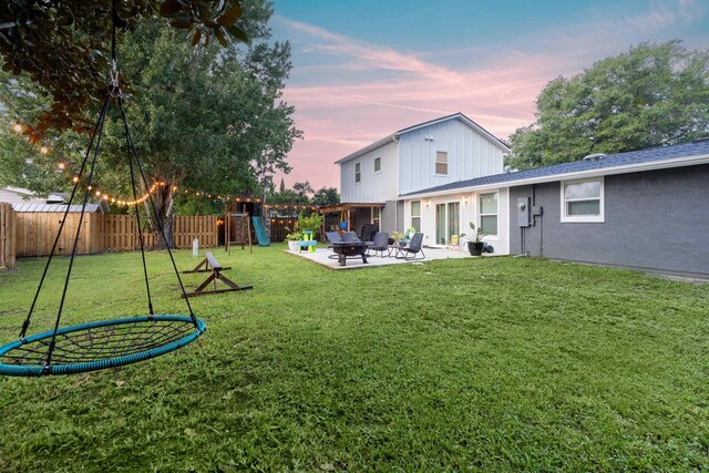 214 Deltona Blvd, Saint Augustine, FL 32086 - yard at dusk with a playground, a fenced backyard, and a patio