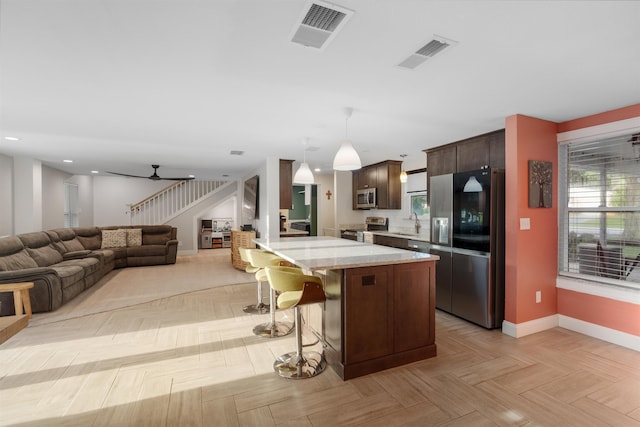 214 Deltona Blvd, Saint Augustine, FL 32086 - kitchen featuring stainless steel appliances, a breakfast bar area, dark brown cabinetry, light stone countertops, and open floor plan
