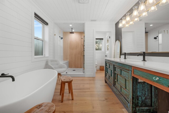 214 Deltona Blvd, Saint Augustine, FL 32086 - bathroom featuring a shower stall, double vanity, wood finished floors, a freestanding tub, and crown molding
