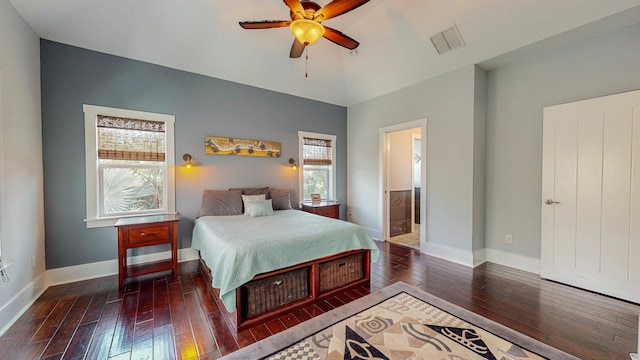 bedroom with multiple windows, dark hardwood / wood-style floors, ensuite bath, and ceiling fan