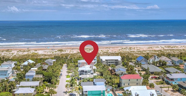 drone / aerial view featuring a water view and a beach view