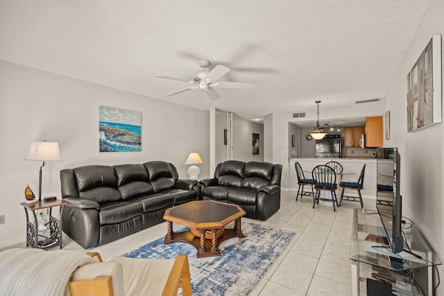 tiled living room featuring ceiling fan and a textured ceiling