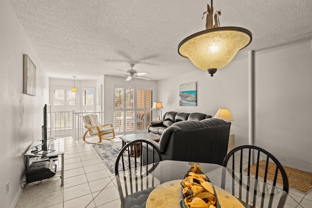 tiled dining space with a textured ceiling and ceiling fan