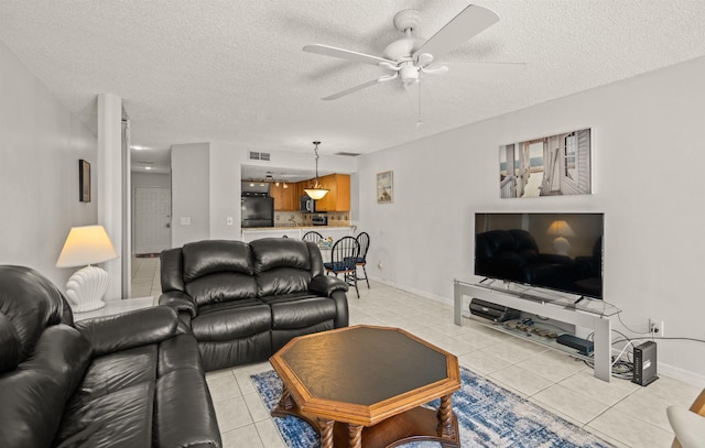 tiled living room with ceiling fan and a textured ceiling