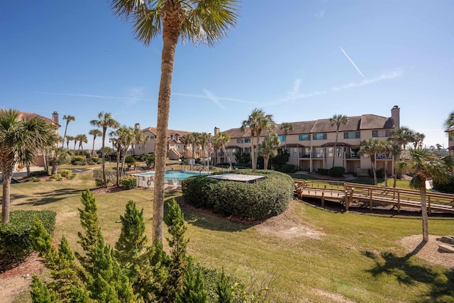 view of community featuring a pool and a yard