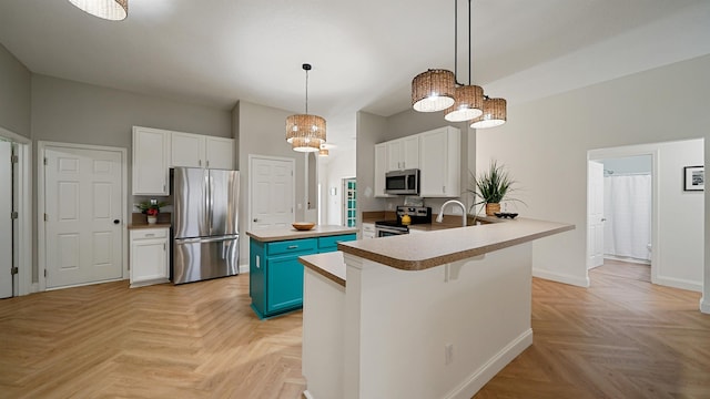2020 Spring Meadows Ct, Saint Augustine, FL 32092 - kitchen with appliances with stainless steel finishes, a center island, white cabinets, and blue cabinetry