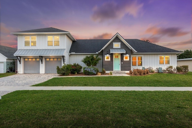 view of front of property with a garage and a yard