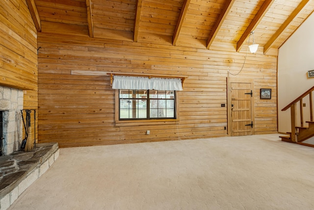 5850 Capo Island Rd, Saint Augustine, FL 32095 - unfurnished living room featuring wooden ceiling, carpet flooring, wood walls, stairs, and a stone fireplace