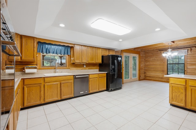 5850 Capo Island Rd, Saint Augustine, FL 32095 - kitchen featuring stainless steel dishwasher, black fridge with ice dispenser, wood walls, light countertops, and healthy amount of natural light
