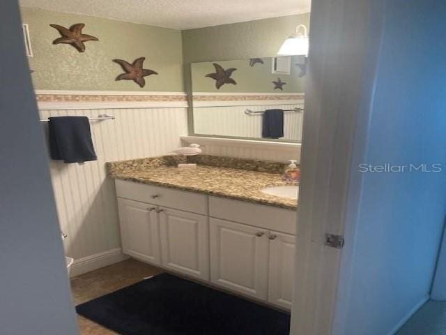 bathroom featuring a textured ceiling and vanity