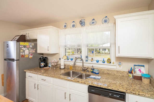 kitchen featuring white cabinetry, sink, light stone counters, and appliances with stainless steel finishes