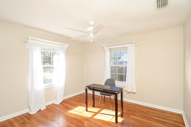 home office with ceiling fan, plenty of natural light, and hardwood / wood-style flooring