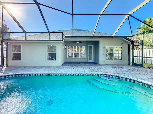 view of pool featuring ceiling fan, a patio, and glass enclosure