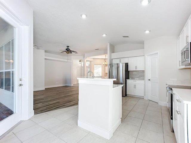 kitchen with white cabinetry, light hardwood / wood-style flooring, a kitchen island with sink, and appliances with stainless steel finishes