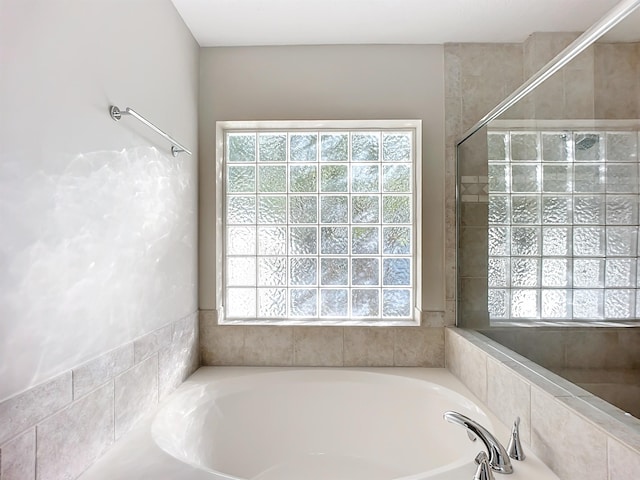 bathroom featuring a relaxing tiled tub