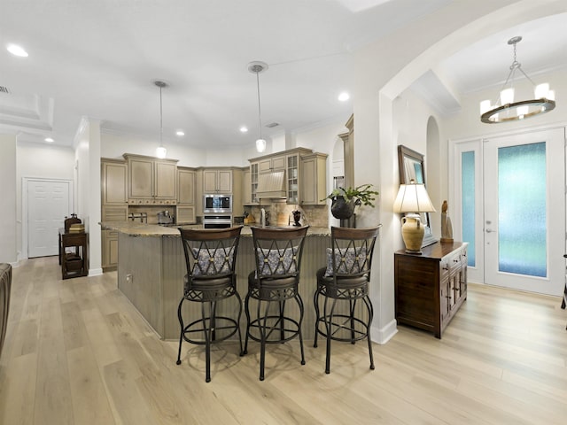 476 Ocean Forest Dr, Saint Augustine, FL 32080 - kitchen with appliances with stainless steel finishes, a breakfast bar area, arched walkways, decorative backsplash, and custom range hood