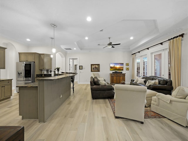 476 Ocean Forest Dr, Saint Augustine, FL 32080 - living room featuring light wood-style floors, arched walkways, ceiling fan, and a tray ceiling