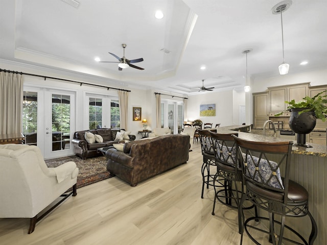 476 Ocean Forest Dr, Saint Augustine, FL 32080 - living room featuring light wood-style floors, ornamental molding, a ceiling fan, and a tray ceiling