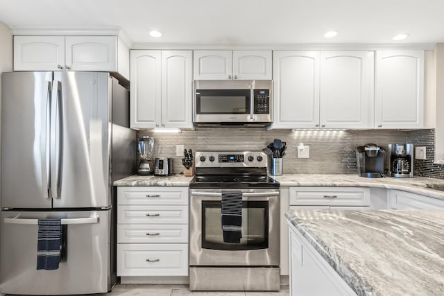 kitchen featuring light stone counters, white cabinetry, and stainless steel appliances