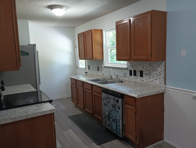 304 Las Olas Rd, Saint Augustine, FL 32084 - kitchen with dishwashing machine, light wood finished floors, freestanding refrigerator, light countertops, and tasteful backsplash