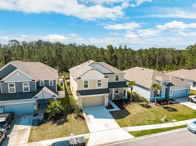 811 Sandstone Dr, Saint Augustine, FL 32086 - view of front of house with a front yard, a wooded view, a shingled roof, concrete driveway, and a garage